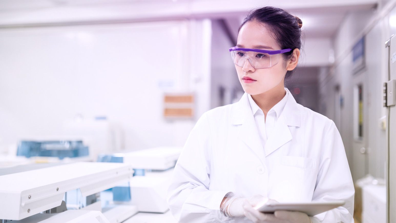 Female healthcare professional in white coat and glasses standing in a hospital corridor, with text overlay 'Our Impact' and a description of the company's commitment to patient care throughout life stages.