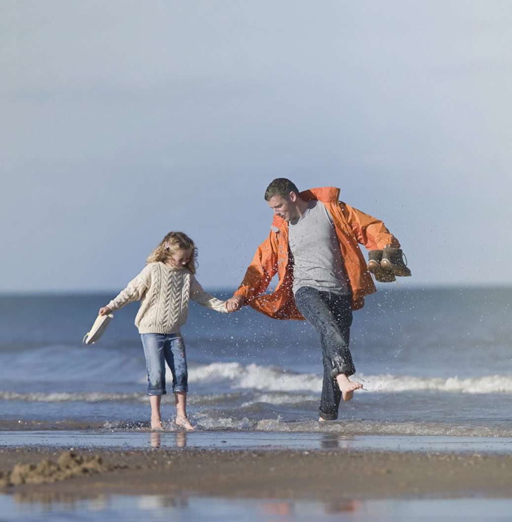 Split image: Purple section with 'Products' text detailing commitment to high-quality medicines, alongside a photo of a father and a daughter on a beach, symbolizing health and well-being.